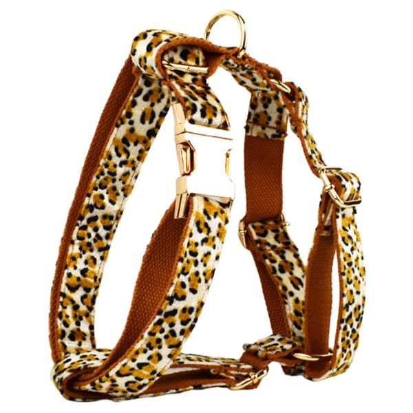 Leopard print dog harness with brown straps on a white background