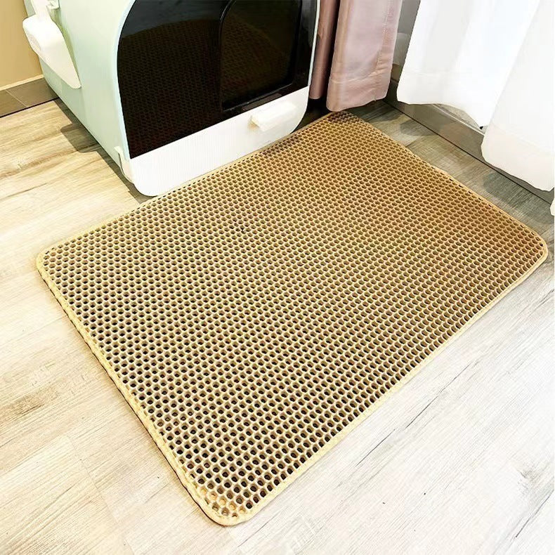 Beige doormat with honeycomb pattern on a wooden floor.